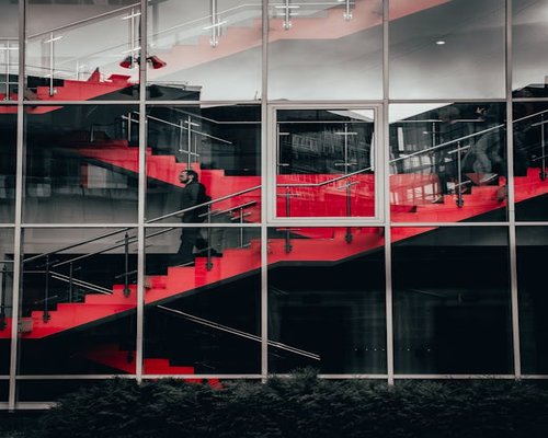 Person taking the stairs thoughtfully in an office building