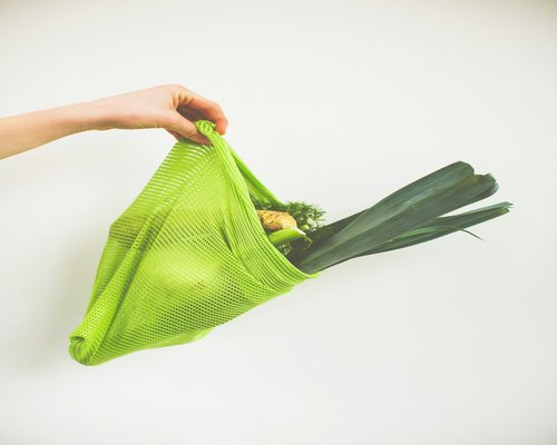 Hands holding a reusable grocery bag comfortably