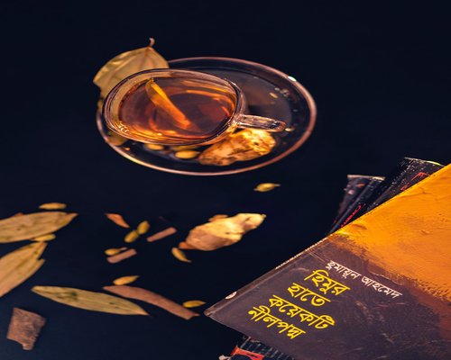 A cup of herbal tea next to a book